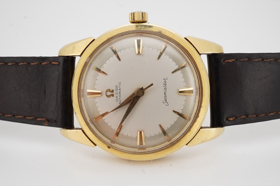 A gentleman's early 1960's 18ct gold Omega Seamaster automatic wrist watch, with baton numerals, movement c. 552, case diameter 34mm, on an associated leather strap. Condition - fair